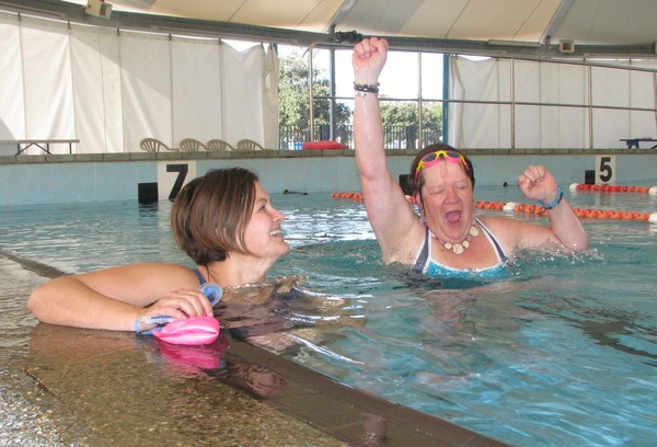 Sue 'The Turtle' Kahu&#8211;Kauika (pictured on the right) punches the air as she learns she is beating her Olympic Pool work colleagues in the Swim to Mahia challenge. Although it is the brain child of receptionist Shannon Friday (left) Sue is ahead of S